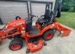 Kubota BX2380 tractor with mower deck, front end loader, and box blade attachments.
