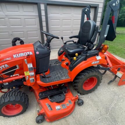 Kubota BX2380 tractor with mower deck, front end loader, and box blade attachments.