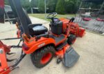 Kubota BX2380 tractor with mower deck, front end loader, and box blade attachments. - Image 3